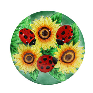 Ladybugs and sunflowers design on a round glass birdbath with vibrant red, yellow, and green colors.