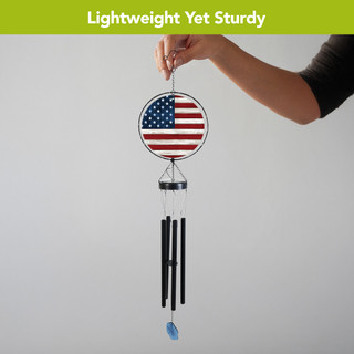 Wood American Flag Illuminated Wind Chime with black tubes and blue pendant, held by hand.