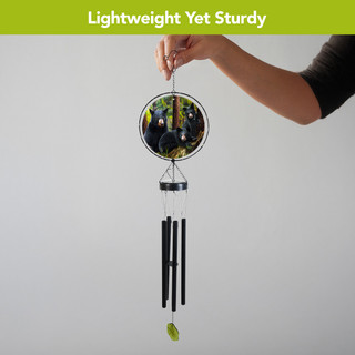 Black Bear Family Illuminated Wind Chime with black tubes and green leaf, held by hand.