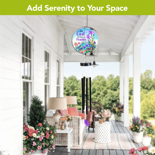 With God Illuminated Wind Chime hanging from a porch ceiling surrounded by flowers and furniture.
