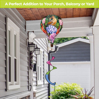Perched Cardinals hot air balloon spinner with colorful tail and vibrant bird design outdoors on porch.