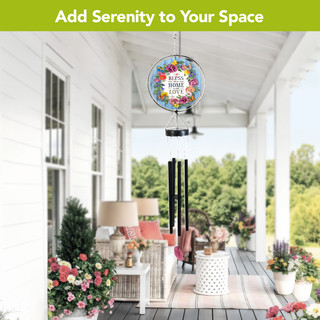 Bless This Home With Love Illuminated Wind Chime hanging on a porch with floral decor.