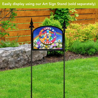 Peace and Love colorful acrylic garden sign with floral design on a black metal stand outdoors.