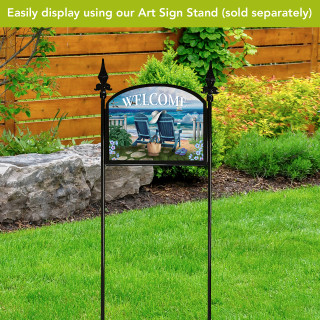 Seaside Escape Acrylic Art Sign on stand with beach scene and Welcome text on garden lawn.