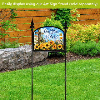 God Bless Our Home Acrylic Art Sign with sunflowers and cross on black stand outdoors.