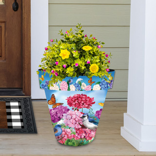 Large colorful planter with vibrant flowers and butterflies, Geraniums in Bloom design on front porch steps.