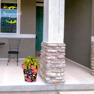 Spring Fling Medium Planter with vibrant floral design and bright flowers on a front porch.