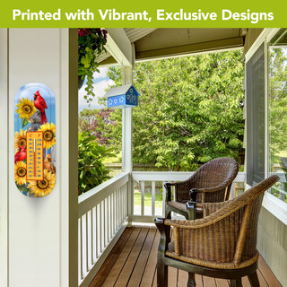 Cardinals and Sunflowers Metal Thermometer with vibrant design on a porch wall beside wicker chairs.