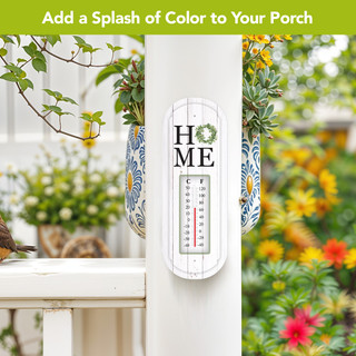 White Home Metal Thermometer with green wreath and black text on outdoor porch post setting.