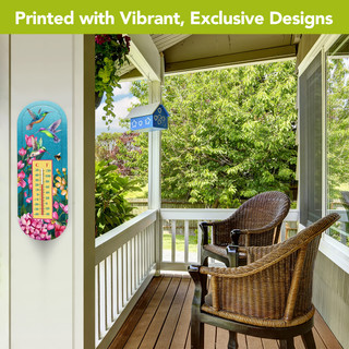 Springtime Hummingbirds Metal Thermometer with colorful flowers and hummingbirds on a white porch wall outdoors.