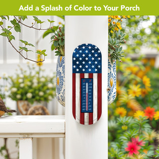Wooden flag metal thermometer with American flag design mounted on a white porch post outdoors.