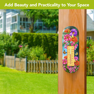 Zinnias in Bloom metal thermometer with colorful floral design on a wooden post outdoors.