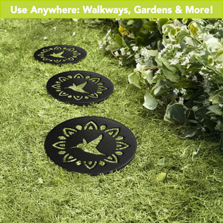 Black Hummingbird Rubber Stepping Stones with green designs on grass with flowers.