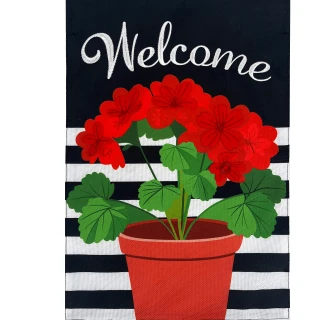 Red geraniums in terracotta pot on black and white stripes garden flag with welcome text.