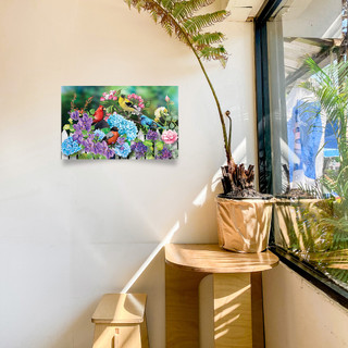 Large LED canvas art with colorful flowers and birds, Feathered Friends, on a white wall.