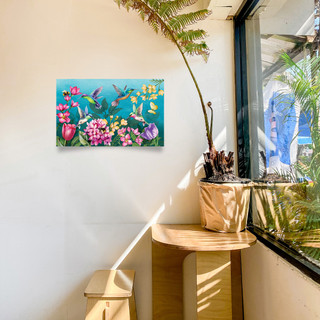 Springtime Hummingbirds Large LED Canvas Art with colorful hummingbirds and flowers on a white wall.