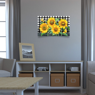 Large LED canvas art with checkered background and vibrant yellow sunflowers in a living room setting.