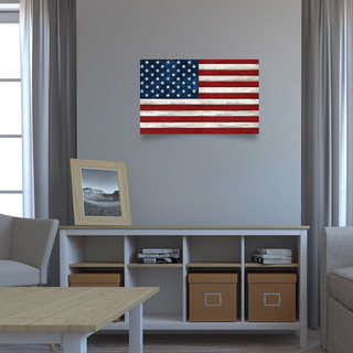 Large LED canvas American flag artwork mounted on a gray wall above a shelving unit.