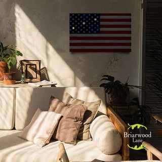 Large LED canvas art of American flag in wood, mounted on a wall above a couch.
