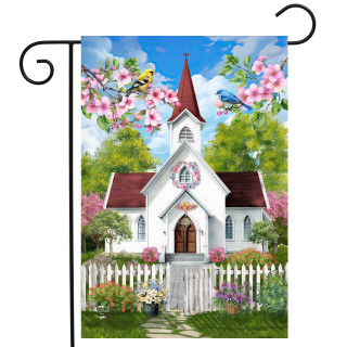 White church with red roof, steeple, and pink flowers on garden flag with white picket fence.