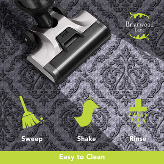 Gray Paisley Large Flocked Doormat with vacuum cleaner on a gray and black floral design background.
