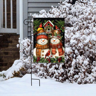 Snowman Pair Garden Flag with festive snowmen, hats, scarves, and holly on a garden stand outside.