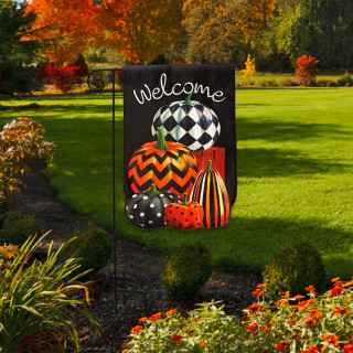 Patterned Pumpkin Stack Burlap Garden Flag with welcome message in a garden setting with pumpkins.
