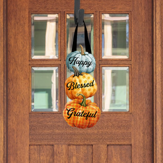 Wooden door hanger with stacked pumpkins reading Happy, Blessed, Grateful in black cursive on each.