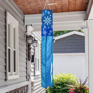 Let It Snow Snowflakes Wind Spinner, blue and white snowflake decoration hanging from a porch roof.