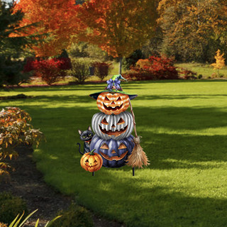 Halloween Pumpkin Stack Metal Art decoration with carved pumpkins and broom on green grass outdoors.