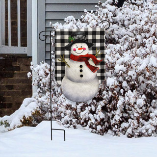 Happy Snowman Burlap Garden Flag with black and white checkered background and red scarf displayed outdoors.
