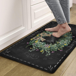 Black Home Sweet Home Wreath Comfort Mat with floral design and person's bare feet standing on it.