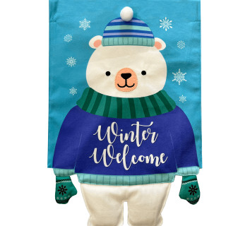 Polar bear in blue sweater, green scarf and hat, on burlap garden flag with snowflakes.