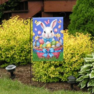 Easter Bunny Basket Garden Flag with colorful eggs and tulips on a blue background displayed outdoors.