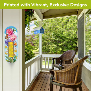 Butterflies and Peonies metal thermometer with vibrant floral design on a porch wall outdoors.