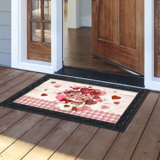 Red and white Love Bouquet Doormat with black border on wooden porch outside open door.