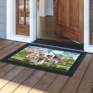 Church in Spring Doormat with colorful floral design and white picket fence on wooden porch.