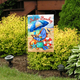 Feelin Beachy garden flag with beach scene, starfish, and colorful summer design on metal stand outdoors.