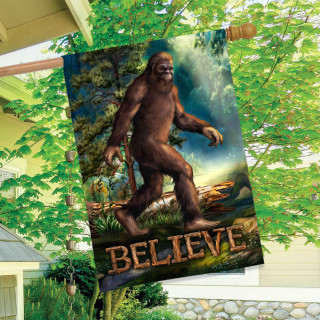 Believe Bigfoot House Flag with brown Sasquatch and Believe text on a garden background.