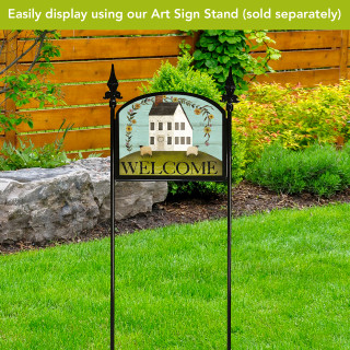 Country Saltbox Acrylic Art Sign with welcome text and house design on a garden stand outdoors.