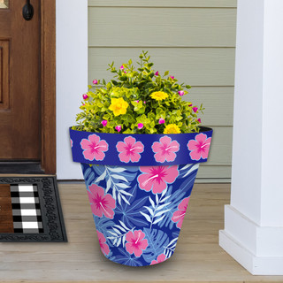 Large blue tropical planter with pink flowers and green leaves, filled with yellow and pink blooms.