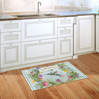Hummingbird Wreath Doormat on wooden floor in front of kitchen sink and white cabinets.