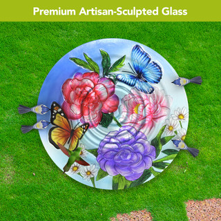 Butterflies and Peonies artisan glass birdbath with colorful flowers and butterflies design on green lawn.
