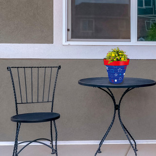 Small Star Spangled Planter with yellow flowers on a black metal table and chair setting.