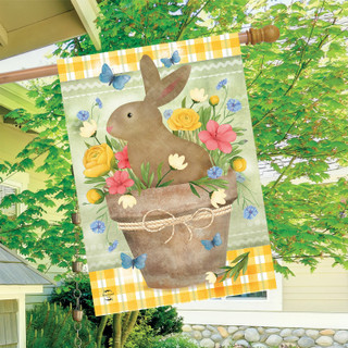 Brown bunny in flowerpot with colorful flowers and butterflies on yellow and white house flag.