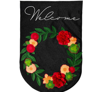 Black burlap house flag with floral wreath and Welcome text, featuring red, green, and peach flowers.