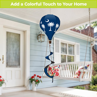 South Carolina Palm Tree Hot Air Balloon Spinner, blue, hanging on a porch with floral decorations.