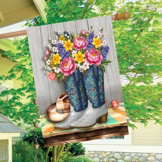Floral Cowboy Boots House Flag with colorful flowers and cowboy hat on wooden background outside.