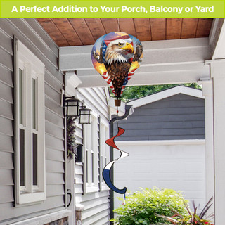 Soaring American Eagle Hot Air Balloon Spinner with patriotic design on a pole outside a house.