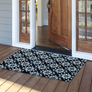 Black and white floral coir doormat, 30 x 48, on a wooden porch outside doorway.